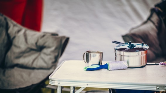 Geschirr liegt auf einem Camping-Tisch. © NDR Foto: Benjamin Hüllenkremer