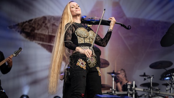 Eine Frau mit langem blonden Haar spielt Geige beim Gothic-Musikfestival M'era Luna 2023. © NDR Foto: Benjamin Hüllenkremer