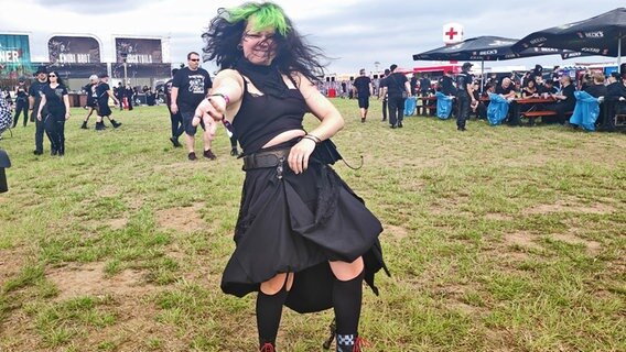 Eine jungen Frau mit einer grünen Haarsträhne tanzt bei einem Festival © NDR Foto: Svenja Estner