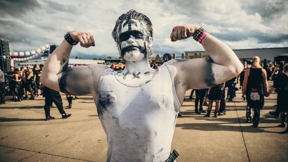 Ein Mann mit muskulösem Oberkörper zeigt seine schwarz-weiße Schminke auf Oberkörper und Gesicht beim M'era Luna Festival 2023 © NDR Foto: Benjamin Hüllenkremer
