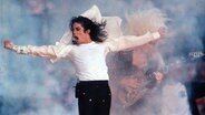Michael Jackson 1993 bei einem Auftritt beim Super Bowl in der Spielpause im weißen Hemd mit viel Nebel auf der Bühne © picture alliance/AP Photo | Rusty Kennedy Foto: Rusty Kennedy