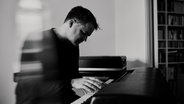 Johannes Motschmann sitzt im Seitenprofil am Klavier © Maximilian König 
