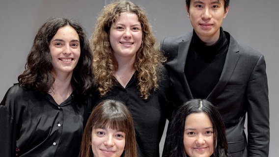Vier junge Musikerinnen und ein junger Musiker schauen nach vorne in die Kamera und sie sind alle in schwarz gekleidet. © Maximilian Busch Foto: Maximilian Busch