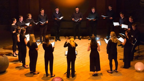 Die ORA Singers stehen im Kreis auf der Bühne © Nick Rutter 