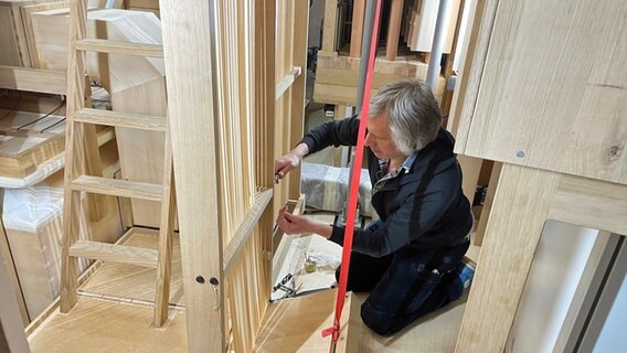 Ein Orgalbauer arbeitet an einer Holzkonstruktion eines Instruments. © NDR Foto: Ulrike Henningsen