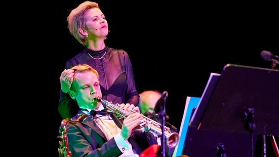 Donatienne Michel-Dansac als Donald Trump mit einem Musiker auf der Bühne der Hamburgischen Staatsoper  Foto: Brinkhoff Mögenburg