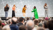 Fünf Sängerinnen und Sänger der Gruppe "The Real Group" auf einer Freilichtbühne. © A-capella-Woche Hannover Foto: Helge Krückeberg