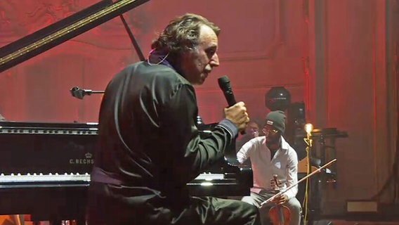 Ein Mann sitzt mit Mikrofon am Klavier. © NDR.de 