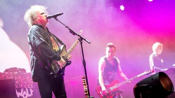 Robert Smith, Frontmann von The Cure (li.), und Band bei einem Konzert in Hamburg. © dpa Foto: Daniel Bockwoldt