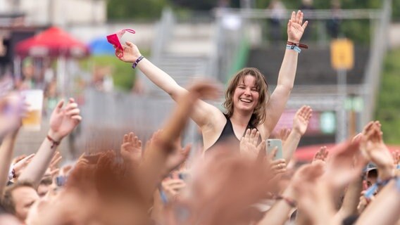 Eine junge Frau feiert auf einem Festival © picture alliance/dpa | Daniel Karmann Foto: picture alliance/dpa | Daniel Karmann