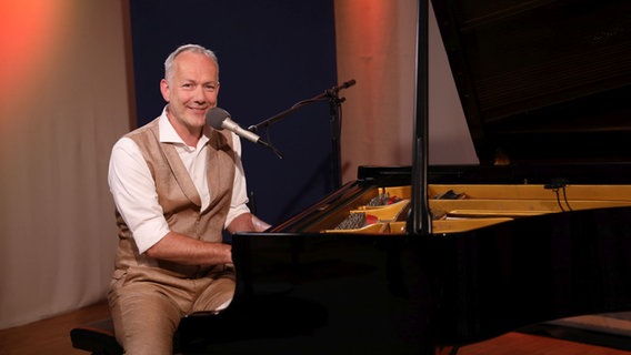 Ein Mann sitzt lächelnd an einem schwarzen Flügel. © Franziska Dieckmann / NDR Foto: Franziska Dieckmann / NDR