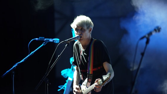 Dirk von Lowtzow, Frontman der Band Tocotronic, steht auf einer Bühne am Mikrofon und singt. © NDR Foto: Niels Grevsen