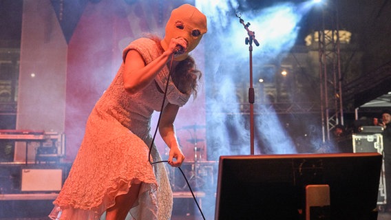 Eine vermummte Sängerin auf der Bühne © picture alliance Foto: Vit Simanek
