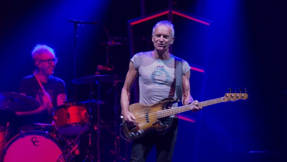 Sting steht mit seiner Bassgitarre auf der Bühne und singt. © NDR 