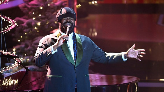 Gregory Porter mit Schiebermütze singt bei einer Weihnachts-TV-Show vor einem Weihnachtsbaum und einem schwarzen Flügel © picture alliance / SvenSimon Foto: SvenSimon