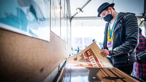 Eindruck vom Reeperbahn Festival 2021: NDR Musikjournalist Matthes Köppinghoff sieht sich Plakate an. © NDR Foto: Julian Rausche