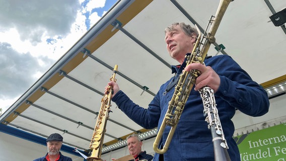 Jan Creutz hält ein Saxophon, eine Klarinette und ein Sarrusophon in der Hand. © NDR Foto: Jan Fragel