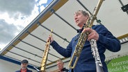 Jan Creutz hält ein Saxophon, eine Klarinette und ein Sarrusophon in der Hand. © NDR Foto: Jan Fragel
