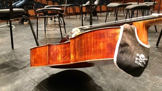 Ein Cello vom NDR Elbphilharmonie Orchester mit einem Lätzchen von St. Pauli im Kursaal  Auditorio in San Sebastián © NDR Foto: Philipp Schmid