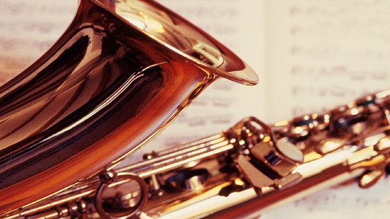 Saxofon liegt auf Notenblatt © www.pixtal.com 