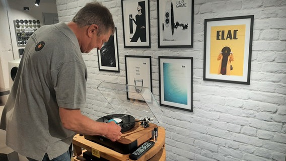Ein Mann steht vor einem Plattenspieler und legt eine Schallplatte auf. Ein Mann steht vor einem Plattenspieler und legt eine Schallplatte auf. © Dudda Foto: Alexa Dudda