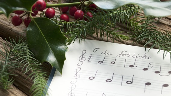Ein Notenblatt zum Lied "o du fröhliche", drumherum Weihnachtsdekoration © Fotolia/ Bidaya Foto: Fotolia/ Bidaya
