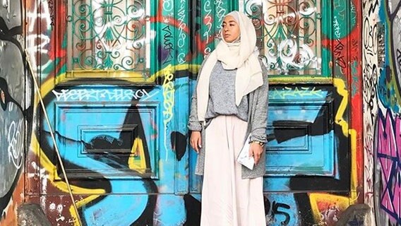 Eine muslimische Frau vor einer Graffiti-Wand © instagram/sanisshining 