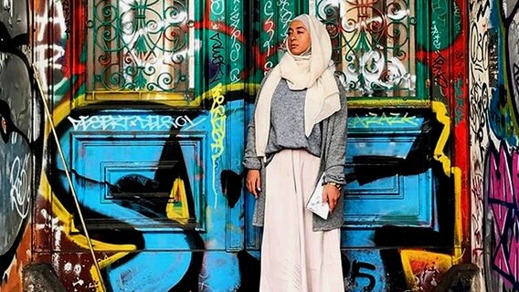 Eine muslimische Frau vor einer Graffiti-Wand © instagram/sanisshining 