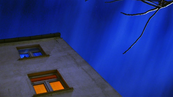 Eine Hausecke mit beleuchteten Fenstern in der Nacht © photocase Foto: Grammbo