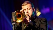 Der Trompeter Nils Wülker spielt mit geschlossenen Augen bei einem Auftritt. © picture alliance/xim.gs Foto: xim.gs / Philipp Szyza