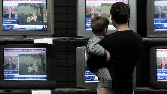 Ein Mann und ein Junge schauen auf viele Fernseher © picture-alliance / dpa/dpaweb | Soeren_Stache 