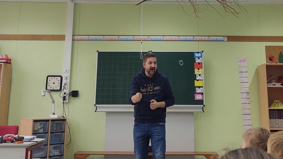 Ein Friesischlehrer steht vor einer Tafel und spricht in die Klasse © NDR.de/ Peer-Axel Kroeske Foto: Peer-Axel Kroeske
