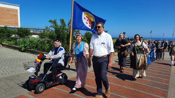 Friesen marschieren mit gemeinsamer Flagge  Foto: Karin Haug