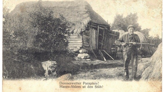 Eine nostalgische Postkarte zeigt einen Mann mit einer Flinte vor einem alten Stall. Eine nostalgische Postkarte zeigt einen Mann mit einer Flinte vor einem alten Stall. © Orts- und Heimatverein Ganderkesee