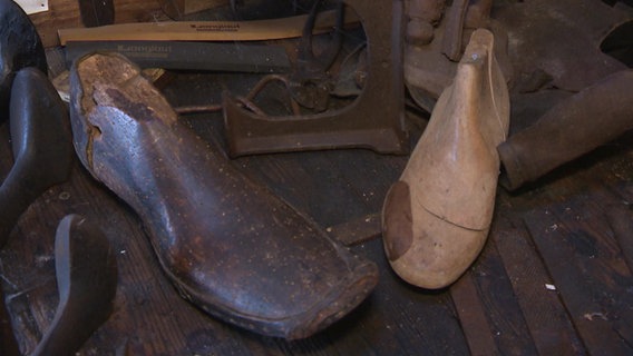 Historische Schuhleisten aus Holz liegen nebeneinander, eine sehr große und eine kleine © NDR 