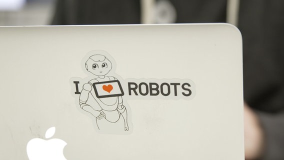 Ein Aufkleber auf einem Laptop, auf dem steht "I love robots". © NDR Foto: Jorrit Groth