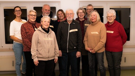 Eine Gruppe von Menschen schaut lachend in die Kamera. © NDR Foto: Lornz Lorenzen