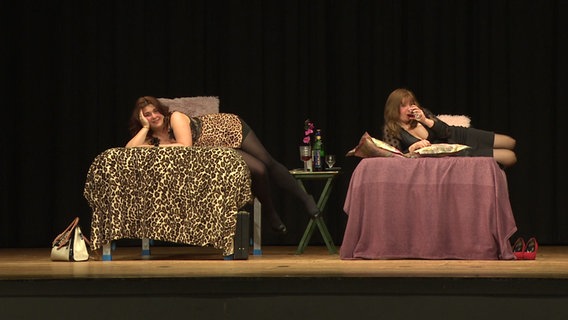 In einer Szene aus dem Stück "De Siedenspringer" liegen zwei Frauen jeweils auf einem Bett. © NDR 