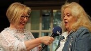 Ines Barber lächelt Sonja Ettler neben ihr auf der Bühne des Ohnsorg Theaters an. © NDR Foto: Oke Jens