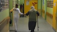 Eine Pflegerin begleitet eine ältere Frau auf ihr Zimmer © picture alliance / dpa Foto: Soeren Stache