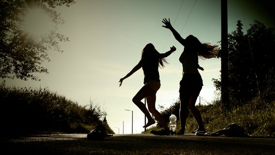 Zwei junge Frauen tanzen wild auf der Straße und fühlen sich gut dabei. © photocase_179479/ Lea! Foto: Lea!
