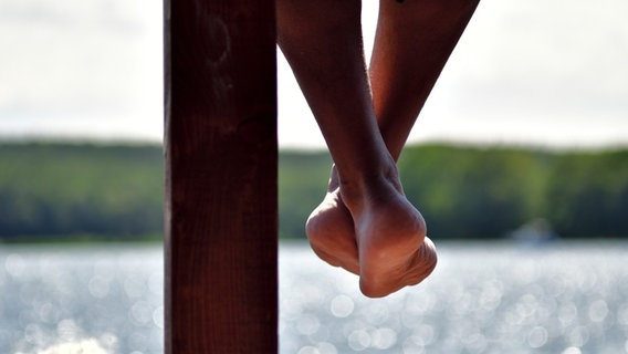 Nackte Beine baumeln über einem Fluss. © TRUELIGHT-NOW / photocase.de Foto: TRUELIGHT-NOW