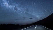 Die Milchstraße über einer nächtlichen Autospur. © Westend61 / photocase.de Foto: Westend61