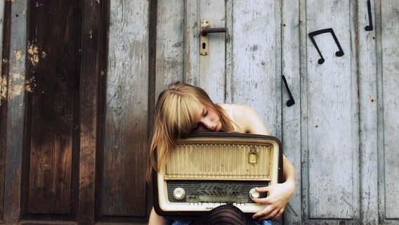 Eine Frau umarmt ein altes Radio. © Fliegenpilz 11 / photocase.de Foto: Fliegenpilz 11