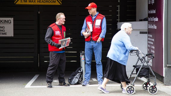 Das Foto zeigt Prinz William, Herzog von Cambridge, der die Straßenzeitung "Big Issue" zusammen mit Big Issue-Verkäufer Dave Martin verkauft. © Andy Parsons/The Big Issue/PA Media/dpa 