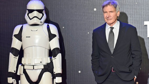 Der Schauspieler Harrison Ford steht bei einer Londoner Filmpremiere von "Star Wars VII" neben der weißen Figur eines Stormtroopers © Facundo Arrizabalaga EPA dpa bildfunk 