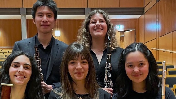 Die Mitglieder des Quantum Quintetts stehen dicht beieinander und posieren mit ihren Instrumenten. © privat 