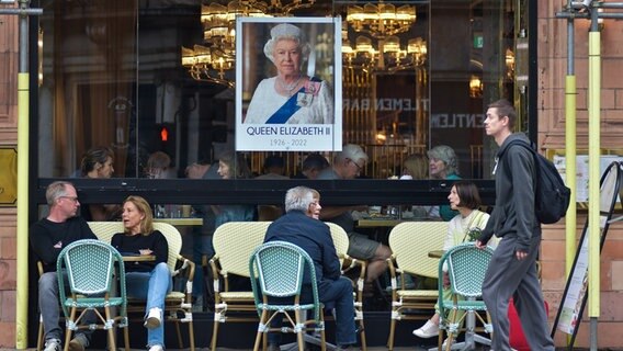 Ein Porträt von Queen Elizabeth II hängt im Fenster eines Cafés © picture alliance/dpa/TASS Foto: Ilya Dmitryachev