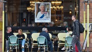 Ein Porträt von Queen Elizabeth II hängt im Fenster eines Cafés © picture alliance/dpa/TASS Foto: Ilya Dmitryachev