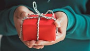 Hände halten ein Geschenkpaket. © Fotolia.com Foto: jakkapan